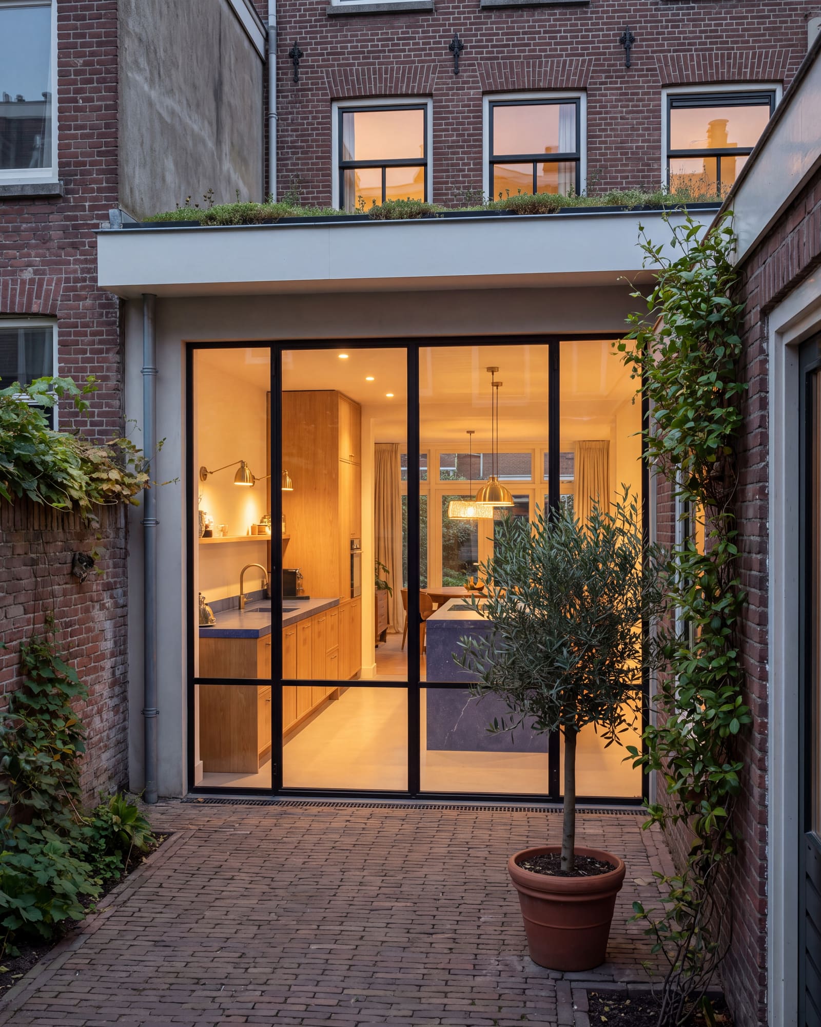 Uitbouw met stalen pui aan een benedenwoning in De Pijp, gezien vanuit de stadstuin