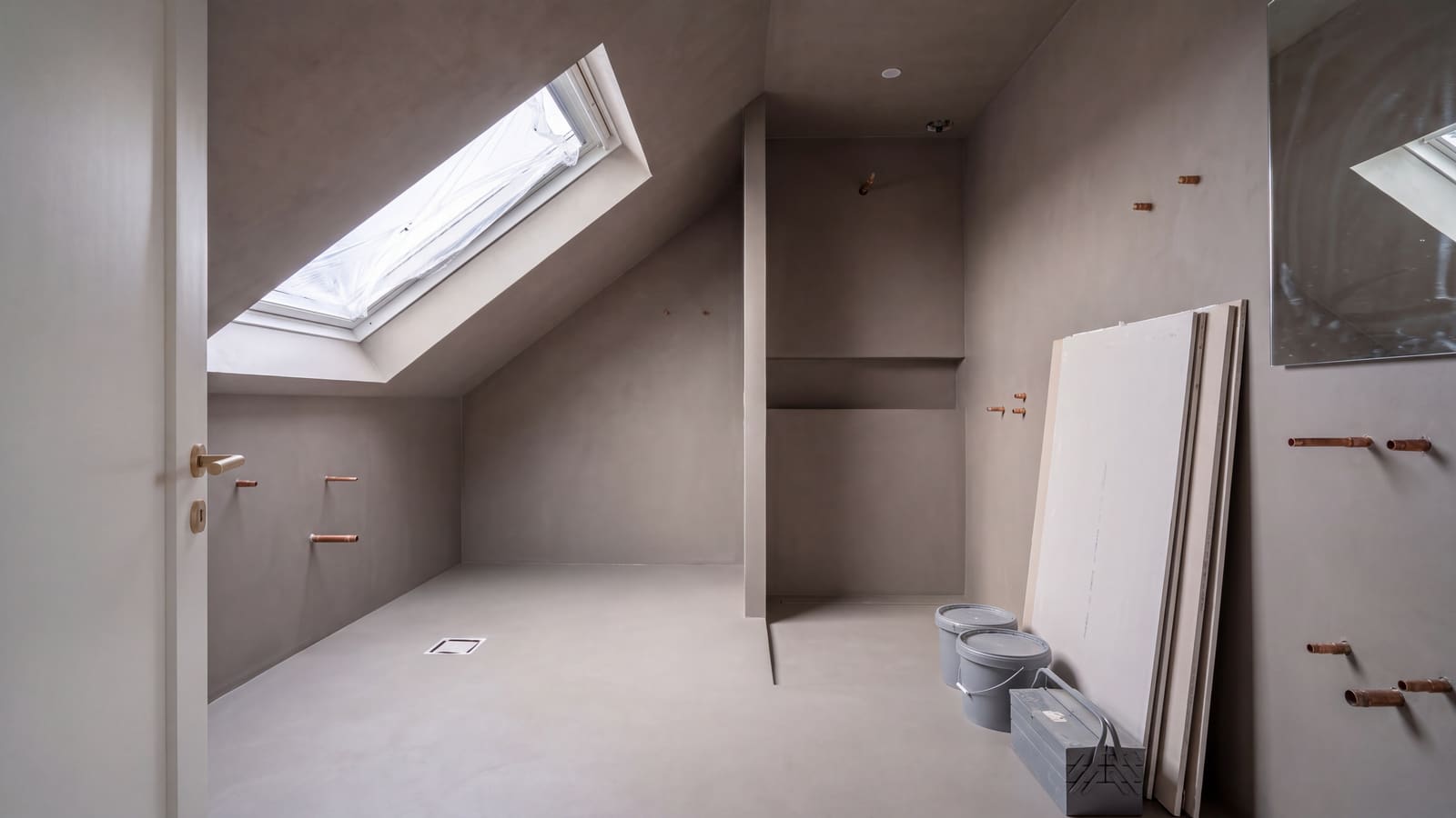 De zolderbadkamer tijdens de afbouw: waterdichte laag, nieuwe leidingen en afvoer